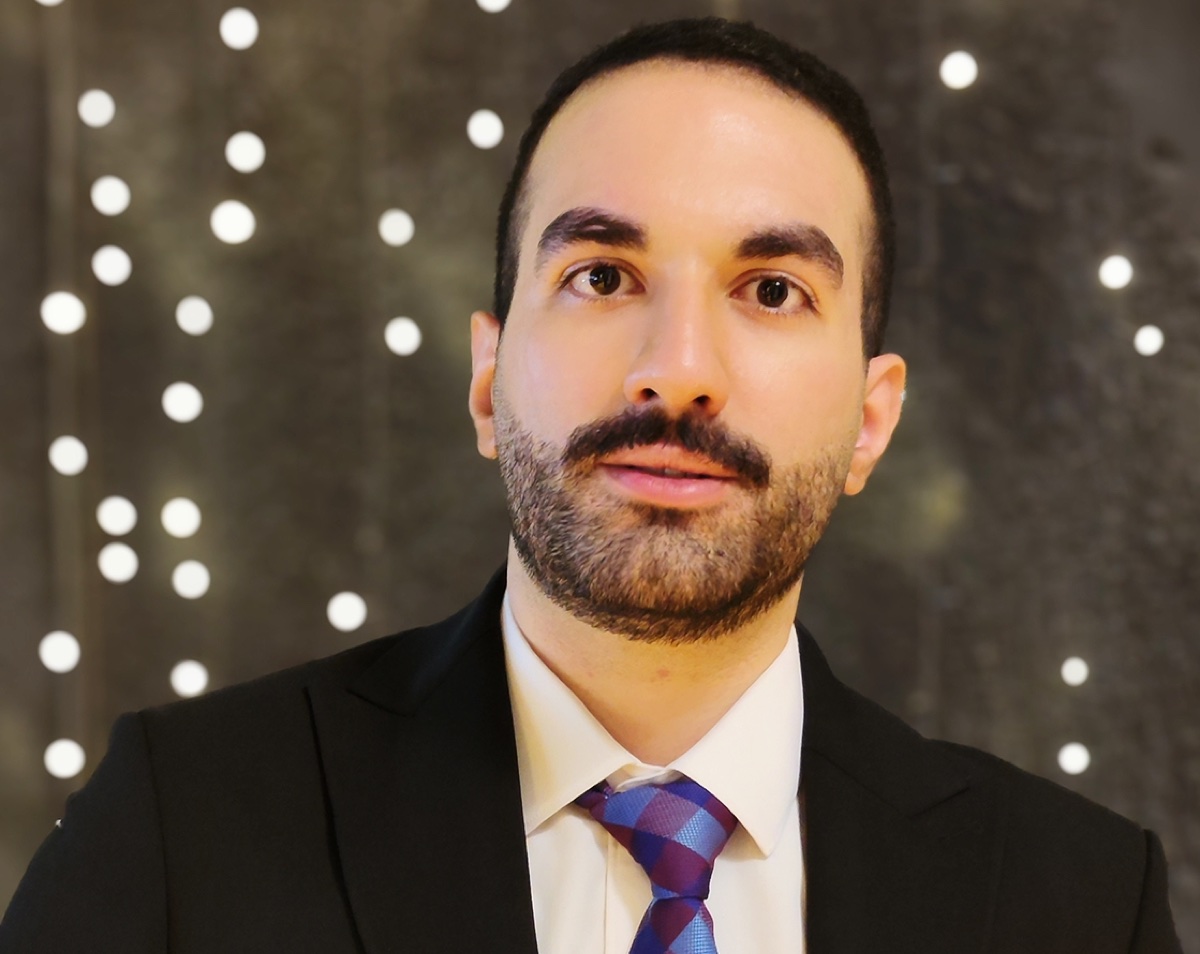Amin Sakha in a dark suit, facing the camera